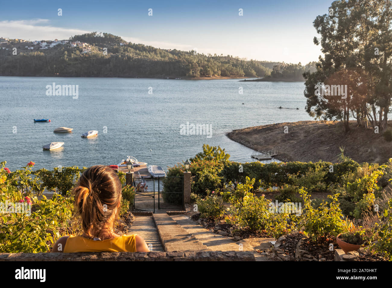 Ragazza seduta con il lago e la vista del tramonto. Foto Stock