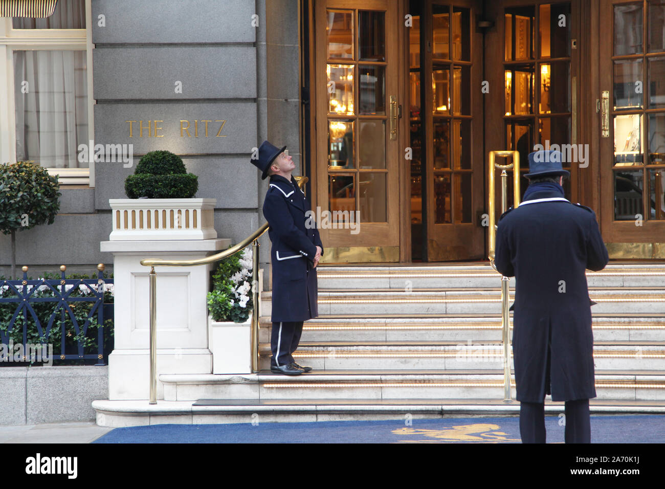 Due portiere stand fuori dell'entrata al Ritz hotel in Arlington Street, Mayfair, Londra Foto Stock