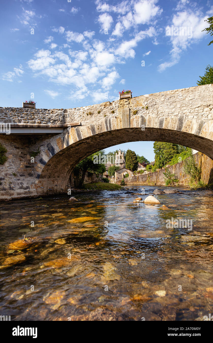 Vista del ponte sul fiume e la chiesa del villaggio Audressein nel dipartimento di Ariège, nei Pirenei, regione Occitanie, Francia Foto Stock