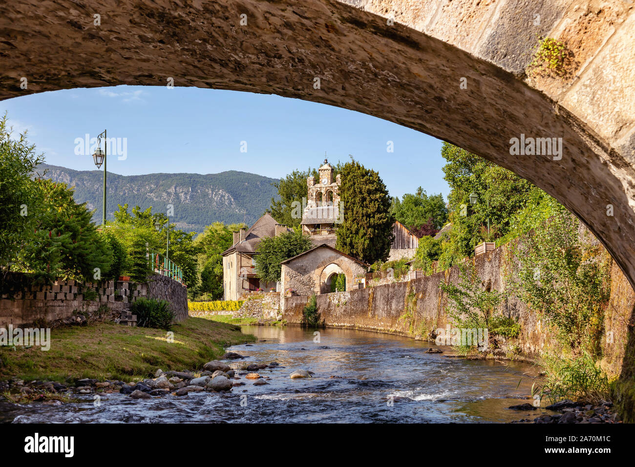 Vista del ponte sul fiume e la chiesa del villaggio Audressein nel dipartimento di Ariège, nei Pirenei, regione Occitanie, Francia Foto Stock