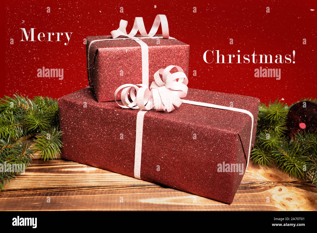Due regali di Natale giacciono su di un tavolo di legno e un messaggio di saluto Foto Stock