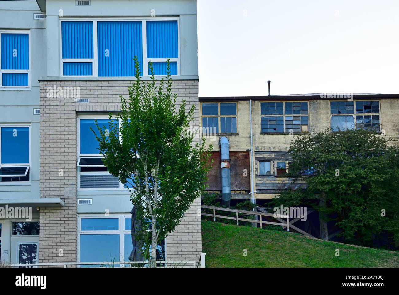 Due edifici di appartamenti uno vecchio con le finestre rotte e non in uso un altro con nuovi rivestimenti e nuove finestre Foto Stock