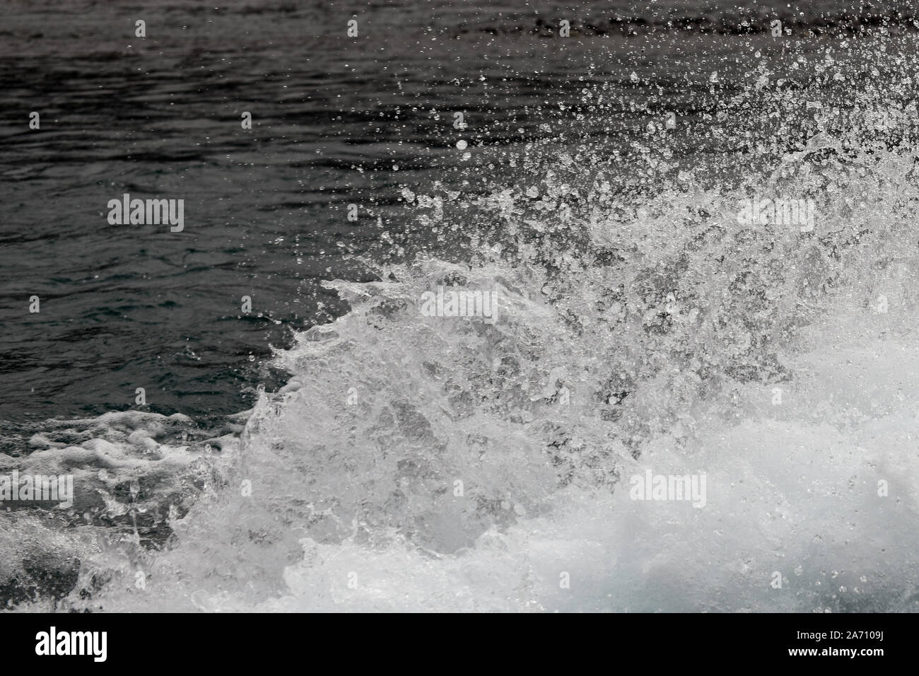 Sullo sfondo di uno spruzzo di acqua e le goccioline di acqua a sinistra sulla scia di una jet boat Foto Stock