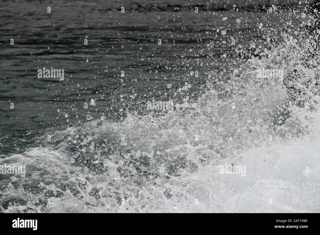 Sullo sfondo di uno spruzzo di acqua e le goccioline di acqua a sinistra sulla scia di una jet boat Foto Stock