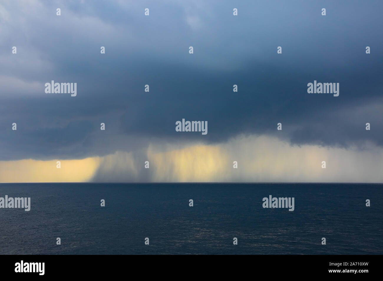 La pioggia e le tempeste sopra l'oceano, su un livello di grigio clound giornata al mare. Foto Stock