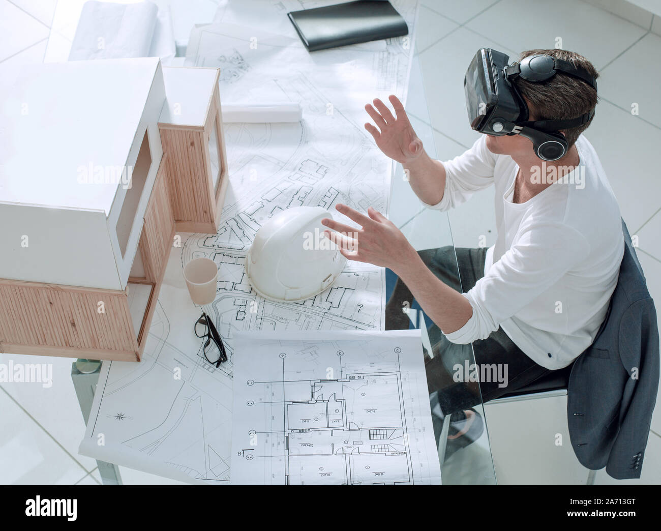 Architetto nel casco di realtà virtuale e ciò seduti a tavola Foto Stock