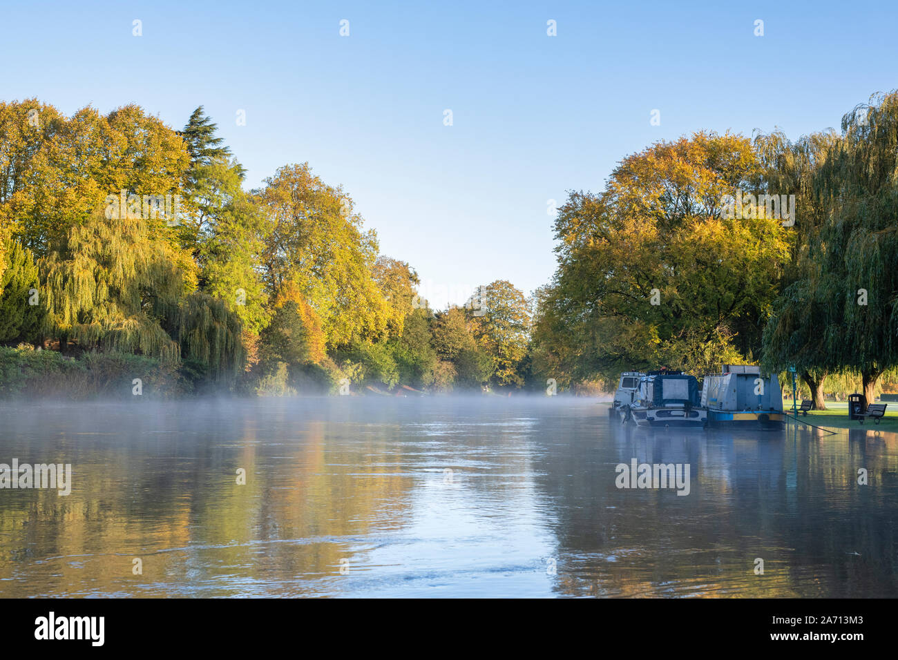 Autunno alberi e narrowboats lungo un invaso il fiume Avon su una mattina di autunno. Stratford Upon Avon, Warwickshire, Inghilterra Foto Stock
