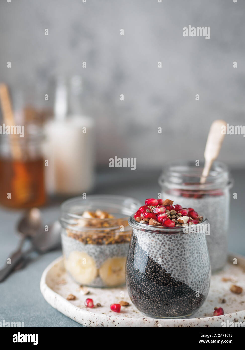 Set di chia pudding in diversi vasi di vetro sul tavolo. Assortimento di chia puding con differenti di frutta,ingredienti. Copia spazio per il testo. Super, detox,sano pernottamento prima colazione concept Foto Stock