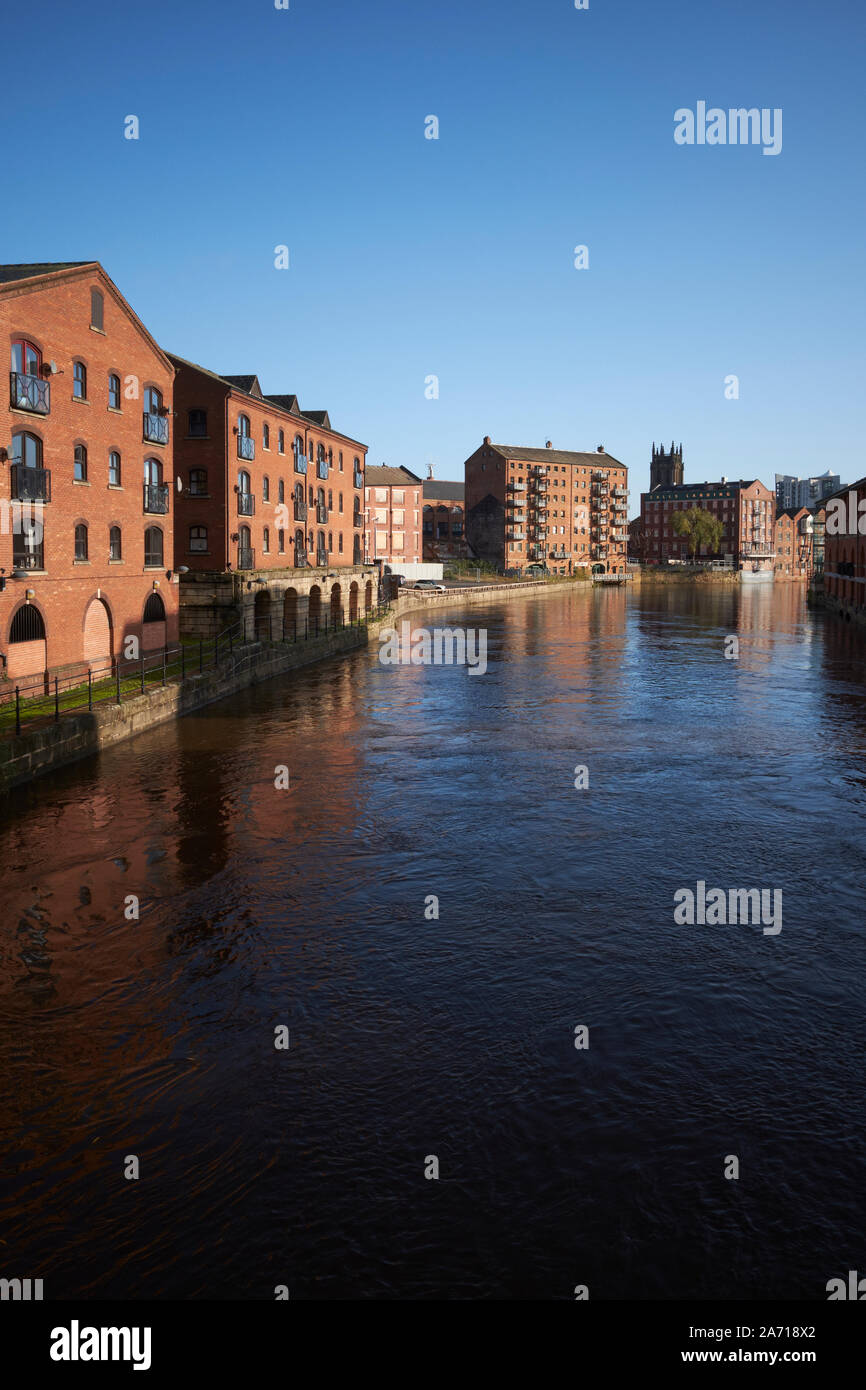 Il fiume Aire a Leeds, nello Yorkshire, Regno Unito, con magazzini convertito sul lungofiume. Foto Stock