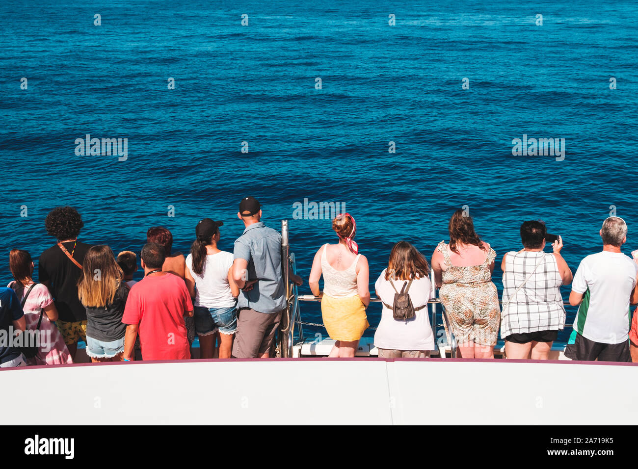 Tenerife, Spagna - Agosto, 2019: gruppo di persone in barca da dietro alla ricerca sull oceano su un whale watching tour Foto Stock