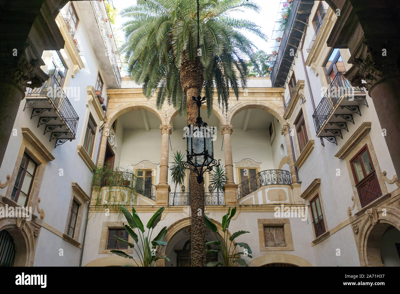 Un hotel Courtyard con una grande palma cresce nel centro. Foto Stock