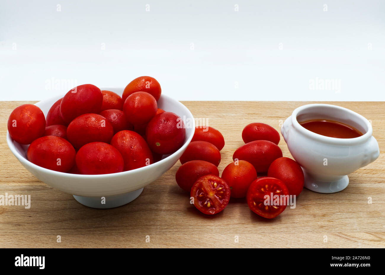 Rosso dei pomodori freschi sul tavolo di legno, sfondo bianco Foto Stock