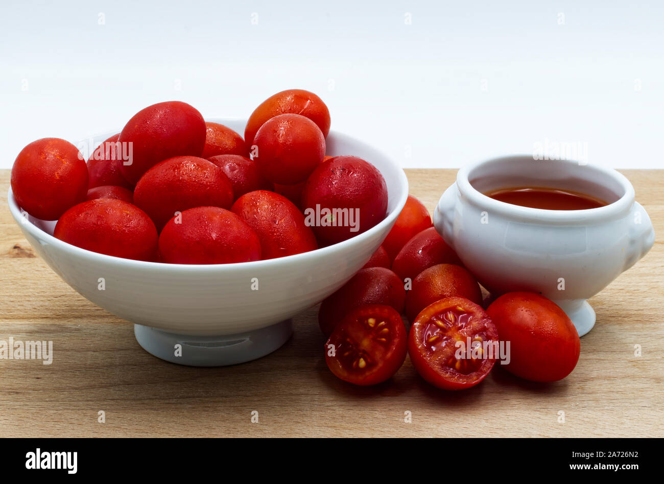 Rosso dei pomodori freschi sul tavolo di legno, sfondo bianco Foto Stock