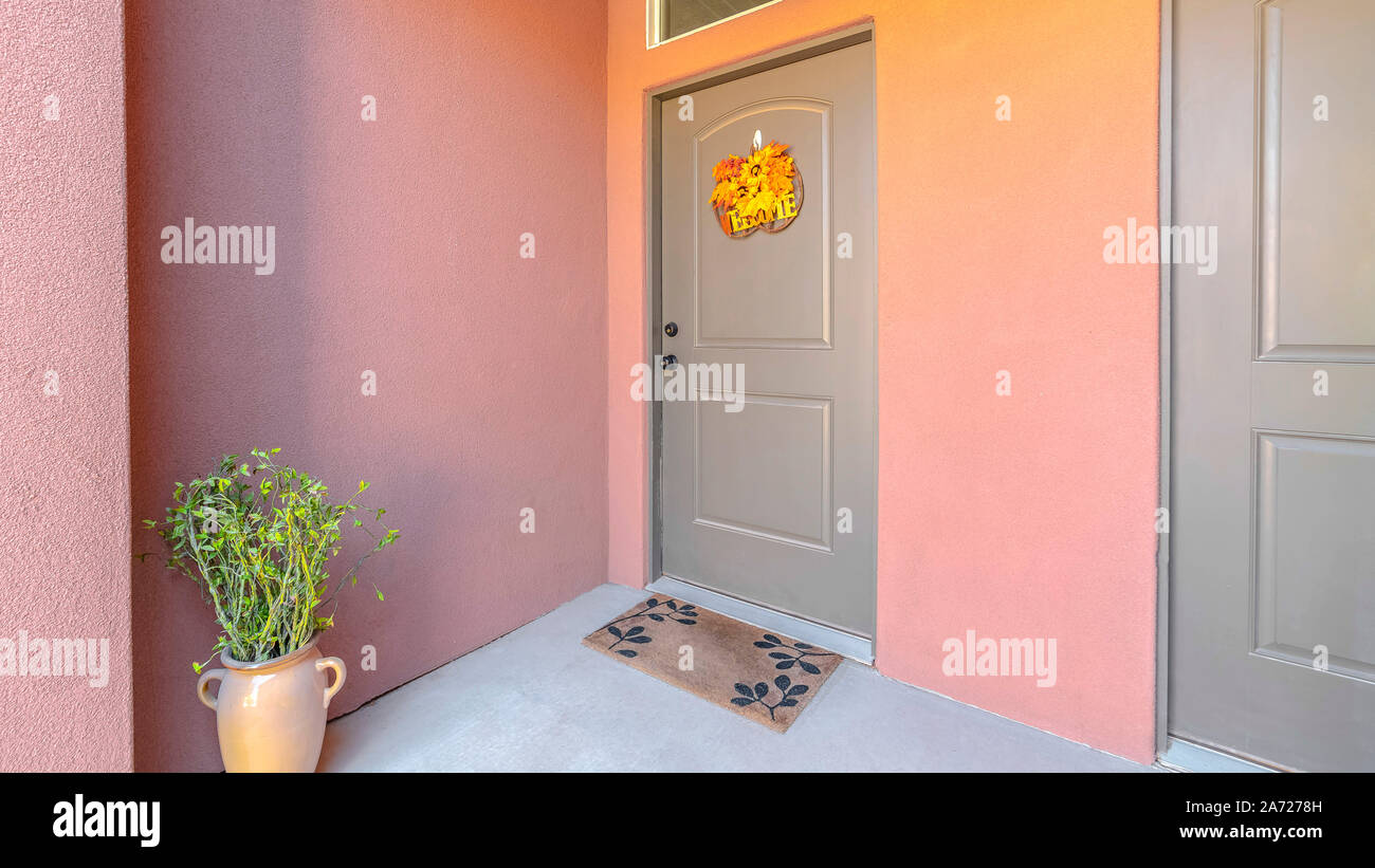 Panorama doppio telaio delle porte anteriori e portico di casa cittadina di colore rosa Foto Stock