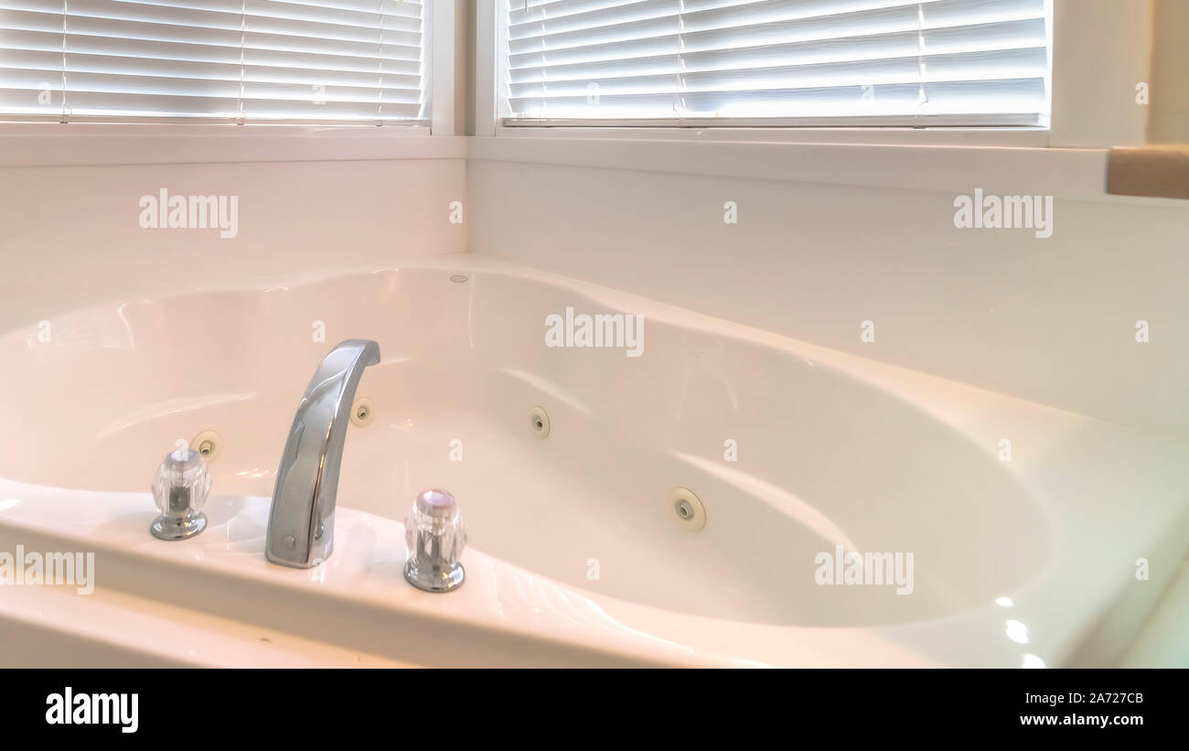 Panorama del telaio fino in prossimità di un bianco brillante vasca da bagno adiacente alla cabina doccia e windows Foto Stock