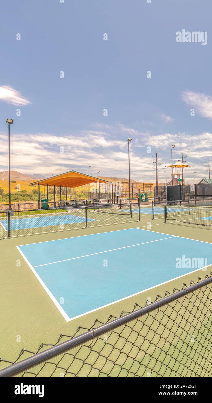 Verticale di campi da tennis all'aperto e soleggiato parco ricreativo Foto Stock