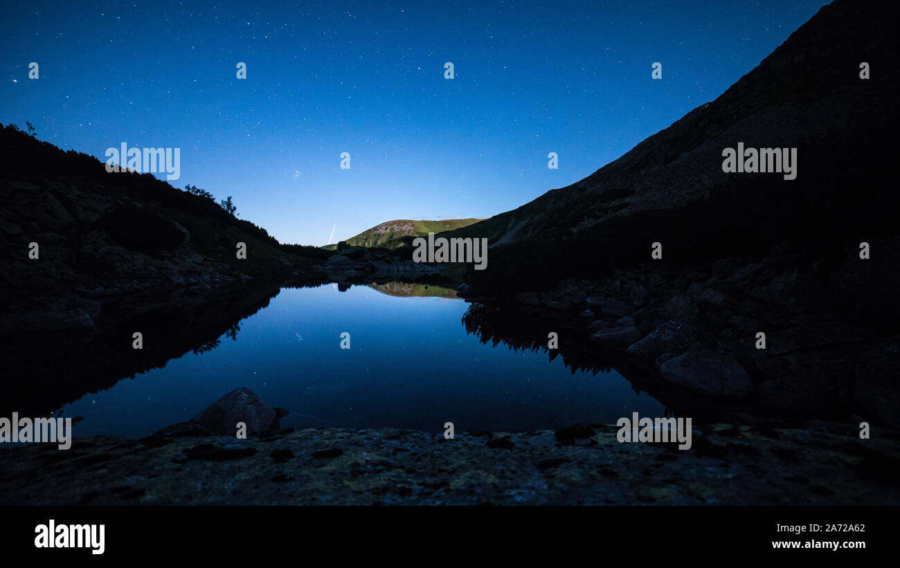 Cielo stellato riflette nelle acque cristalline del lago alpino nei Bassi Tatra in Slovacchia Foto Stock