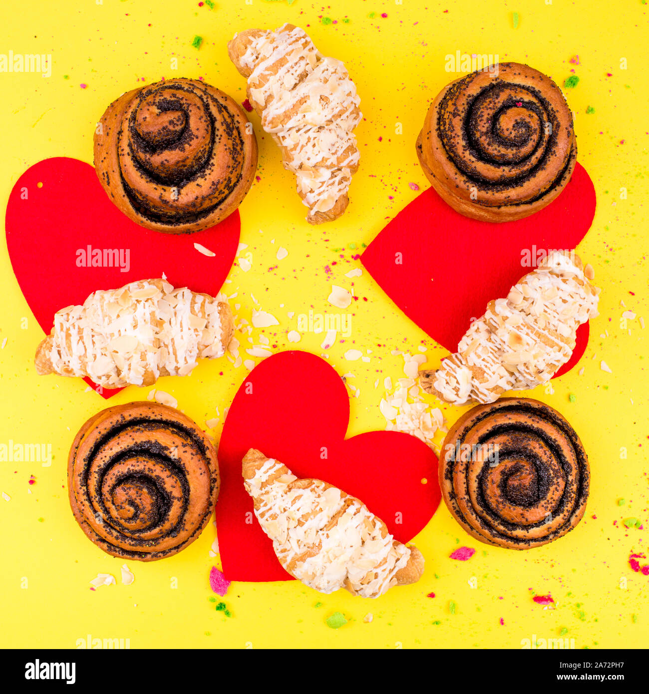 Delicato croissant con noci e mandorle su sfondo giallo. Foto Stock