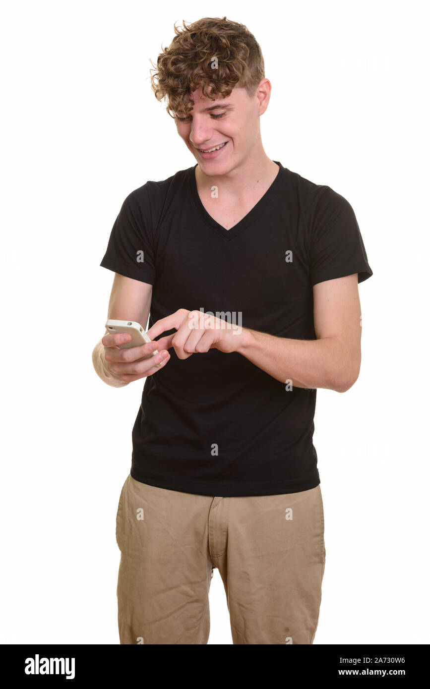 Giovane uomo bello con ricci capelli biondi usando il telefono Foto Stock