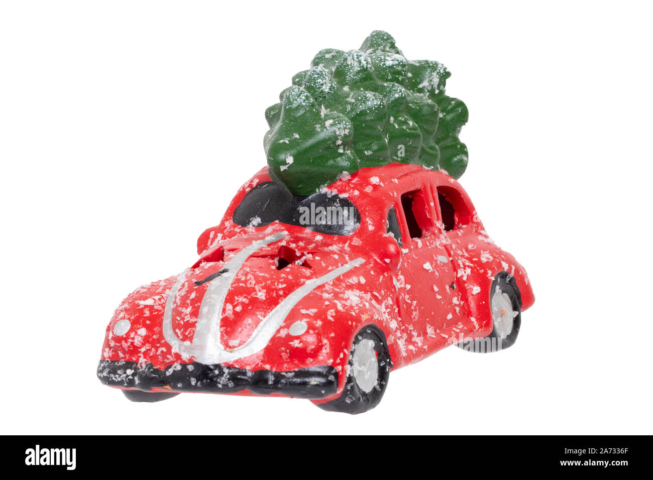 Le decorazioni di Natale sfondo. Primo piano di una coperta di neve rossa giocattolo auto con verde abete bianco sul tetto isolato su uno sfondo bianco. Stagionale desig Foto Stock
