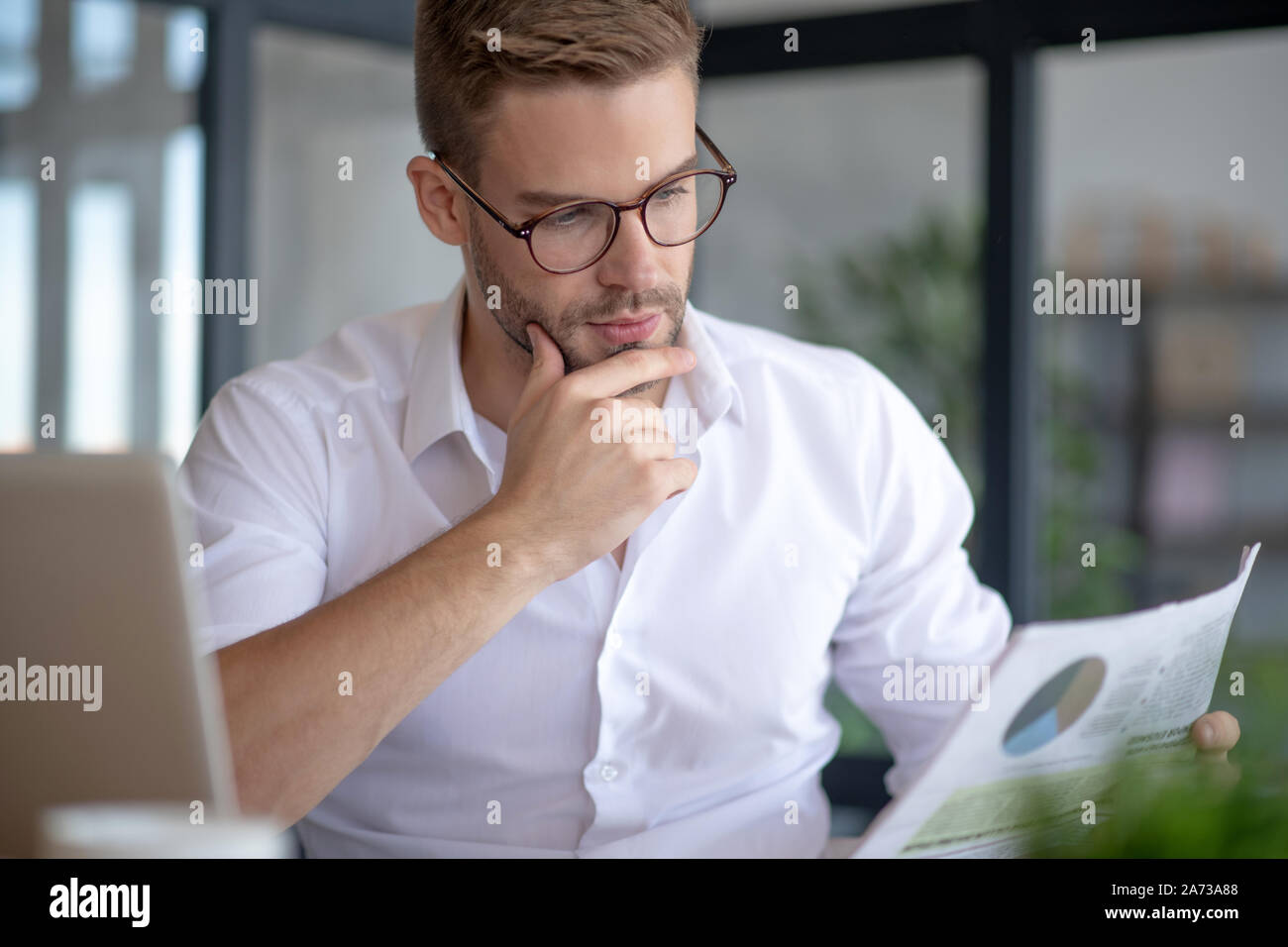 Imprenditore belli con gli occhiali lettura notizie finanziarie Foto Stock