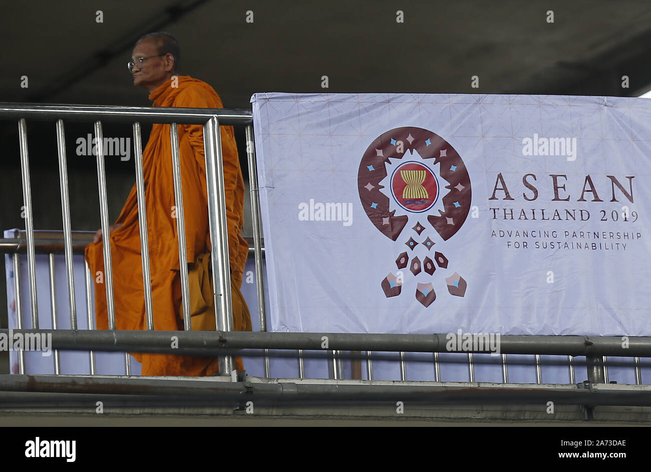 Bangkok, Tailandia. 30 ott 2019. Un monaco buddista passeggiate passato un banner accogliente l'Associazione delle nazioni del sud-est asiatico (ASEAN) leader davanti del trentacinquesimo vertice ASEAN a Bangkok, in Thailandia. Credito: Chaiwat Subprasom SOPA/images/ZUMA filo/Alamy Live News Foto Stock