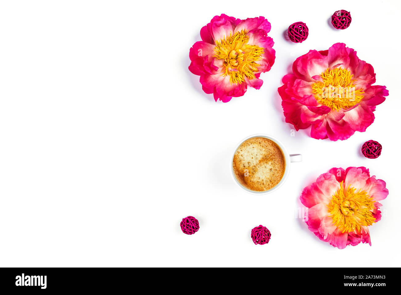 White tazza di caffè e bellissime le peonie sul bianco isolato desk. Appartamento laico, vista dall'alto, copia dello spazio. Foto Stock