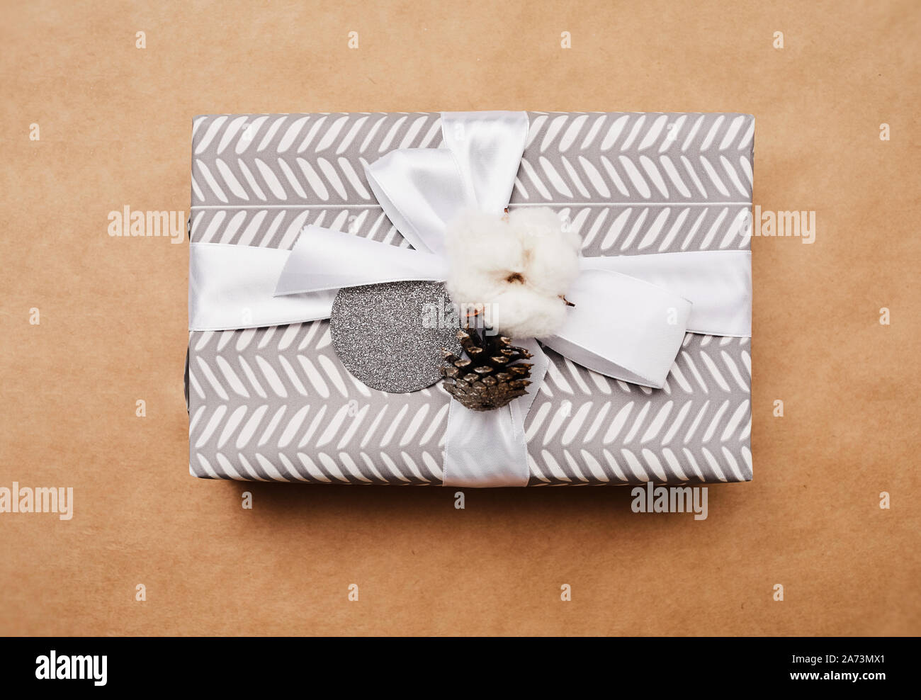 Close-up del bellissimo regalo di natale Scatola decorata con nastro bianco su sfondo marrone Foto Stock