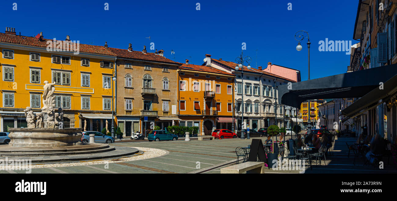 Vista di Piazza Vittoria (Piazza della Vittoria), la piazza centrale di Gorizia con la fontana di Nettuno e edifici colorati sulla giornata di sole, Italia Foto Stock
