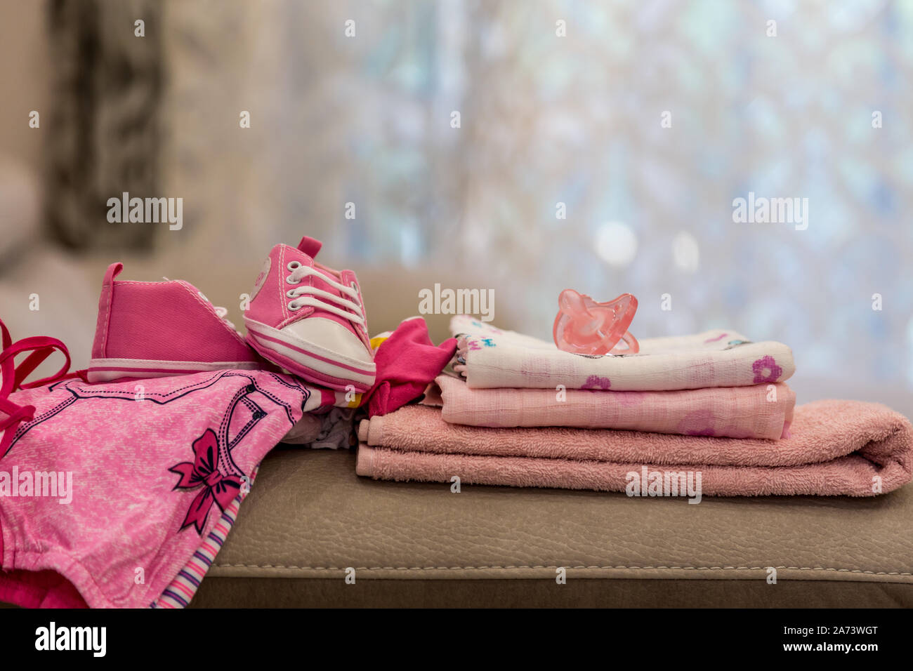 Pila di vestiti del bambino, rosa dummy e rosa Scarpe bambina. La donna incinta è sempre pronto per l'ospedale di maternità, imballaggio baby stuff. La gravidanza, il concetto di nascita Foto Stock