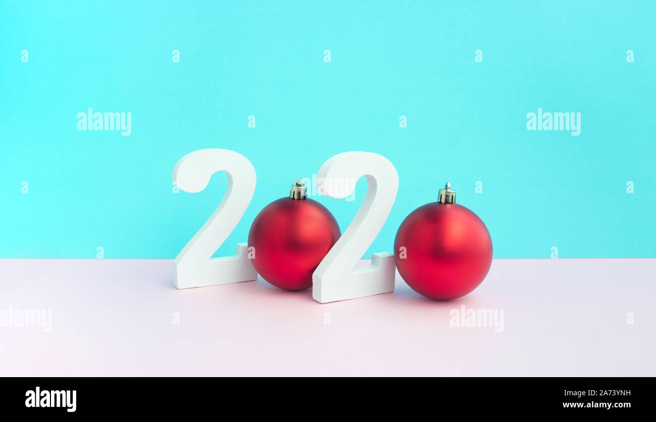 Festa di Natale concetti idee con mock up 2020 numero di testo e la sfera rossa ornamento sui colori pastello sfondo.decorazione per celebrare il design della scheda. Foto Stock