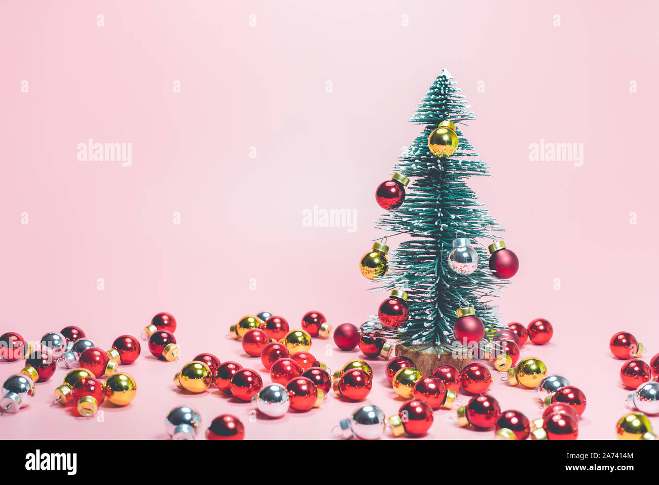 Festa di Natale concetti idee con graziosi pino e sfera rossa ornamento sui colori pastello sfondo.decorazione per celebrare il design della scheda. Foto Stock