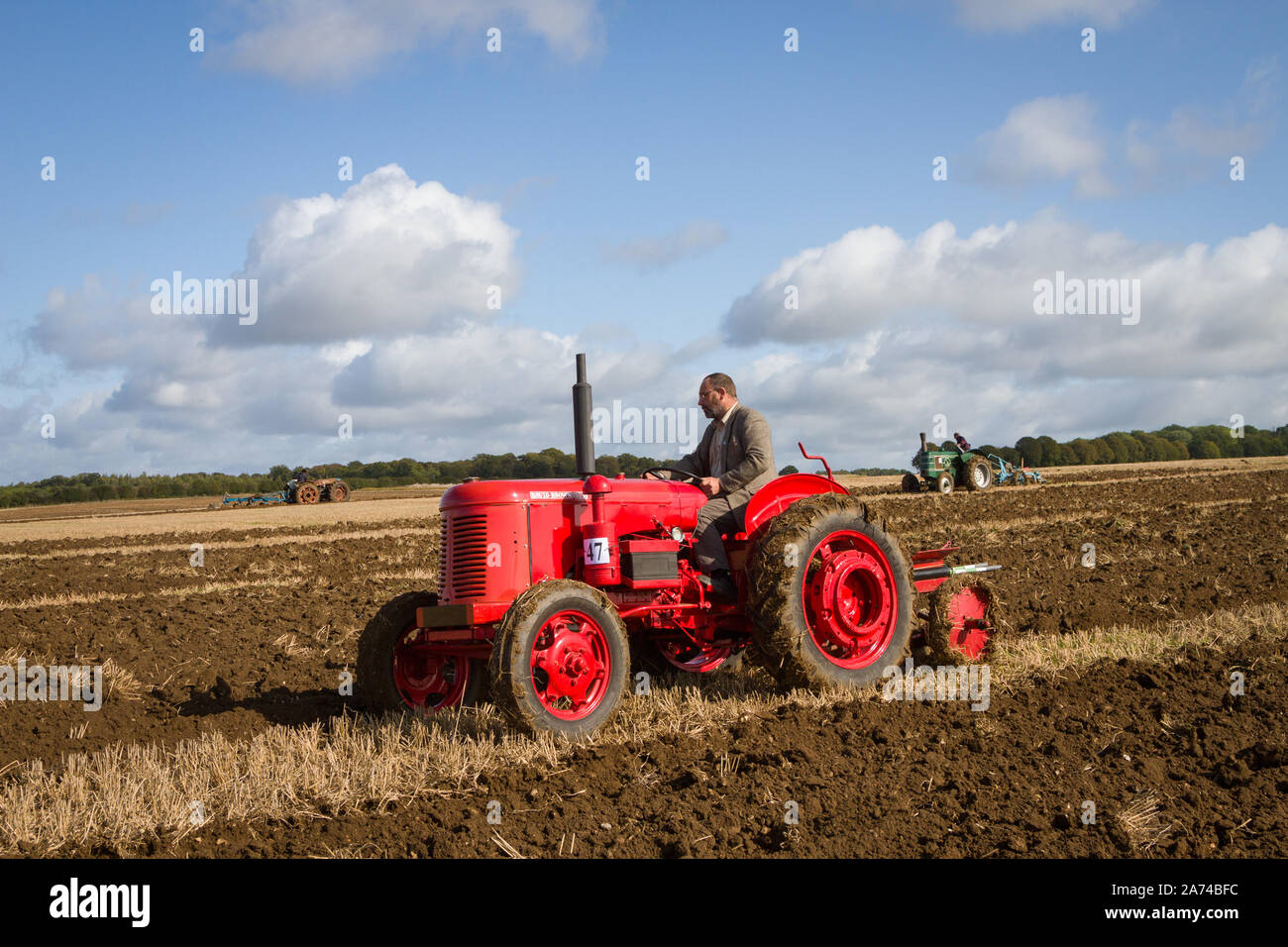 Un trattore David Brown d'epoca in una partita di aratura a Ipsden sul bordo delle Chilterns sotto un cielo blu e le nuvole di Cumulus Foto Stock