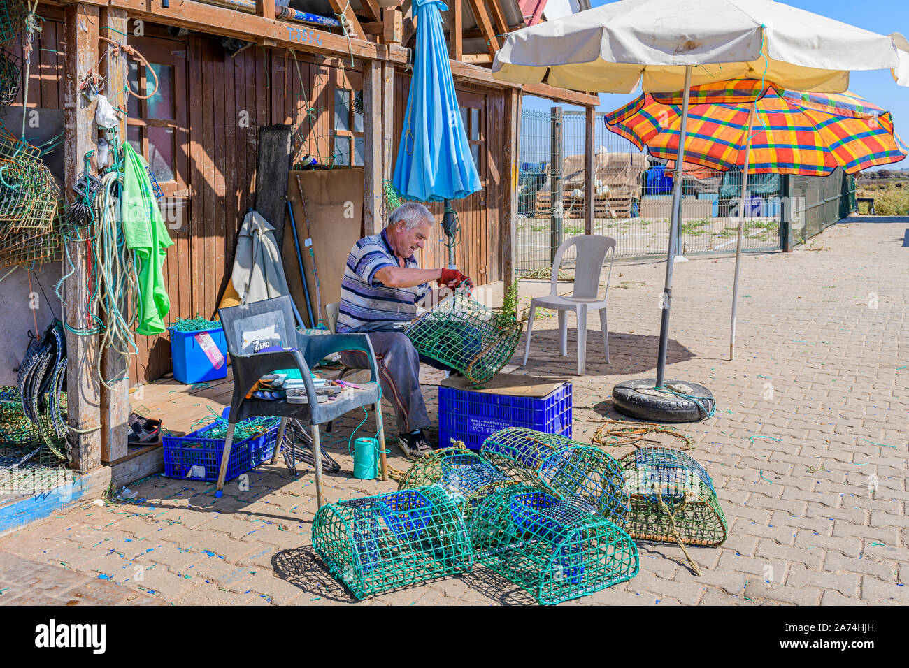 Pescatore locale riparando fissando reti di polpo minacciando trappole pentole rete di pentola, Santa Luzia, Algarve orientale, Portogallo. Foto Stock