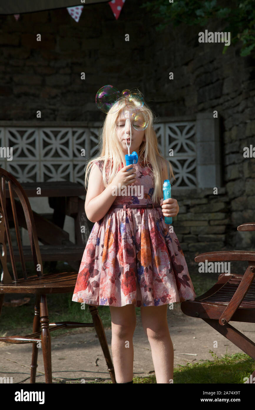 Bambina che soffia bolle in giardino (il rilascio del modello può essere possibile su richiesta) Foto Stock