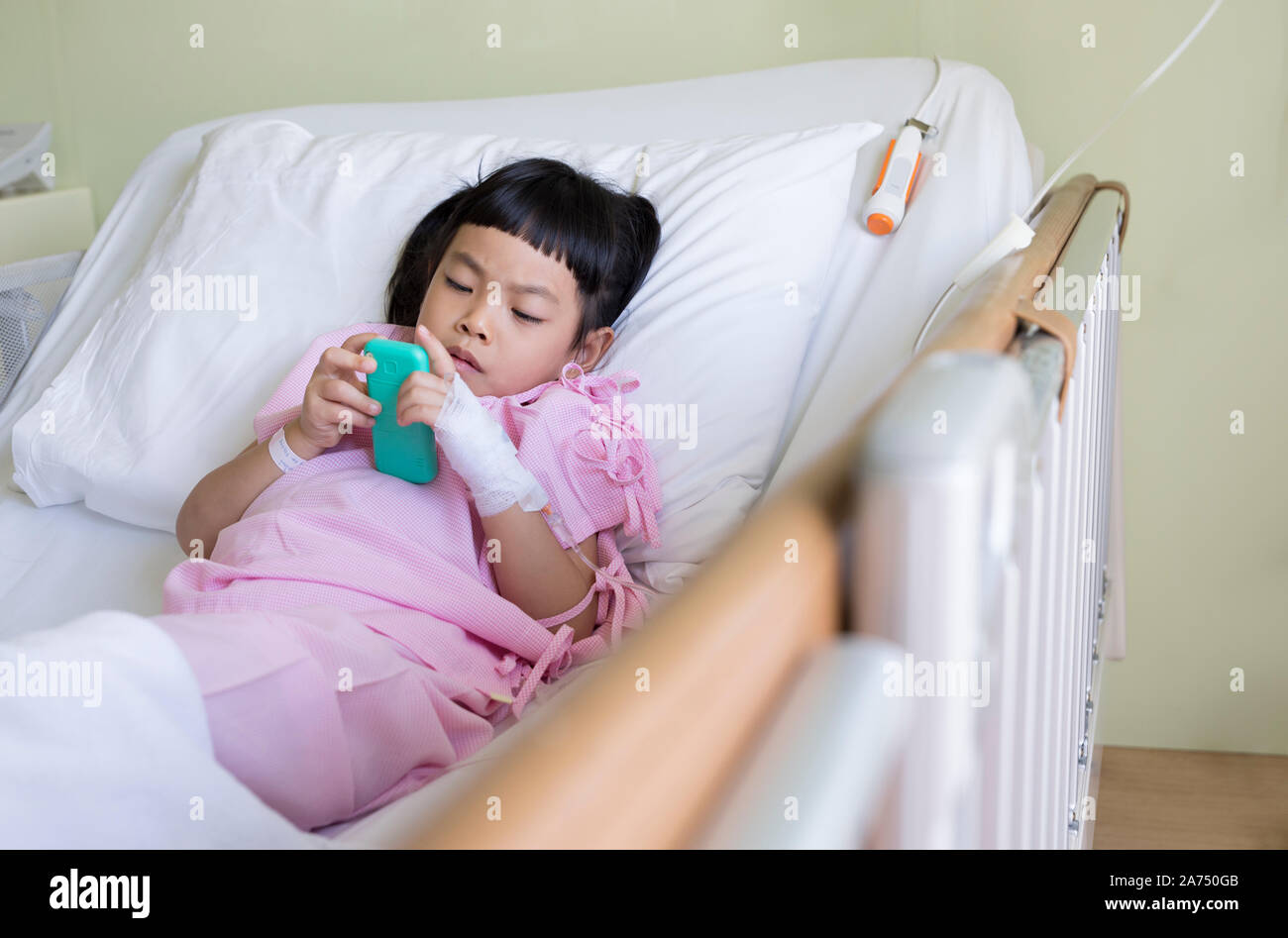 Paziente asiatico bambino o paziente asiatico bambino gioca una partita in un letto d'ospedale. Foto Stock