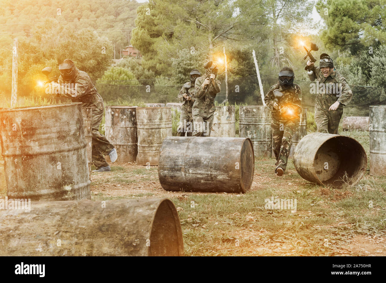 Dynamic paintball battaglia. Gruppo di giocatori in camuffamento attaccando squadra opposta Foto Stock