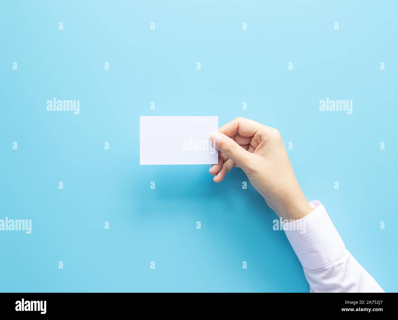 Donna mano azienda vuoto nome business card paper isolato su sfondo blu con una copia dello spazio. Foto Stock