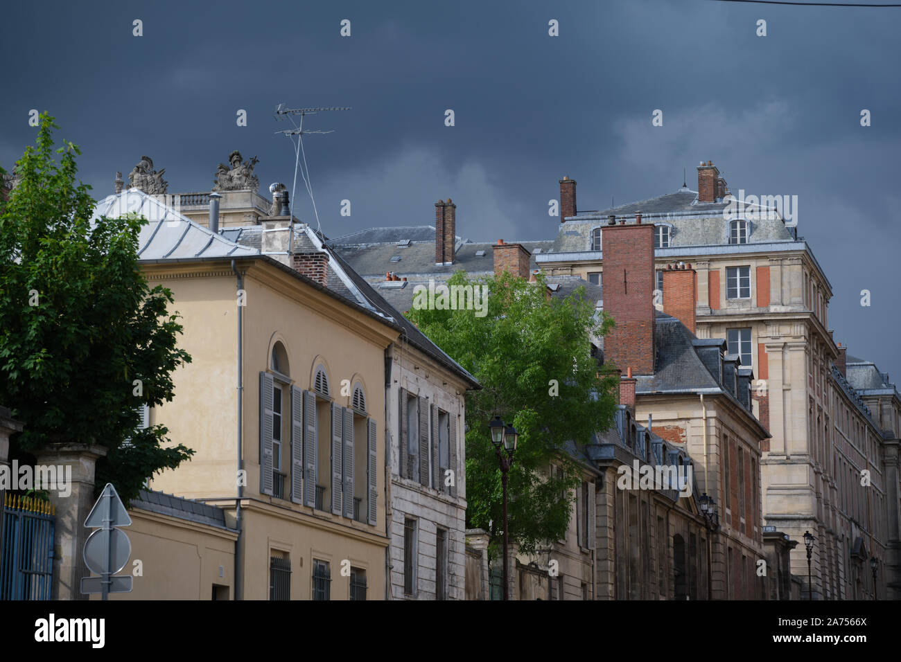 Parte del Castello di Versailles dietro alcune case Foto Stock