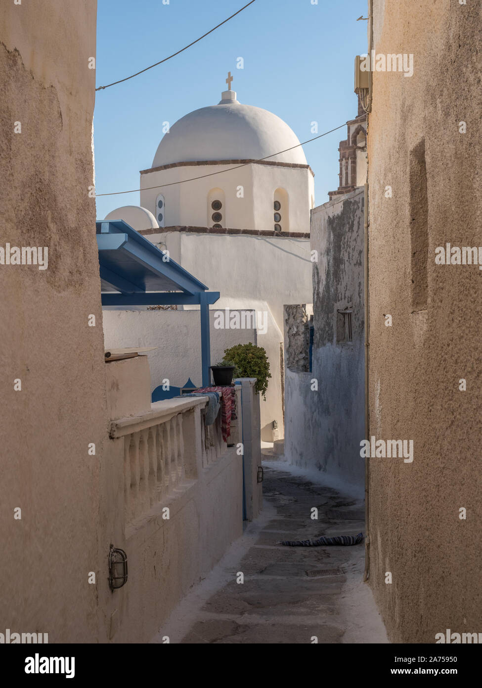 Una vista di una sfumatura ombra back street in epoca medievale città Emborio village alla chiesa cappella pareti strette Santorini Foto Stock