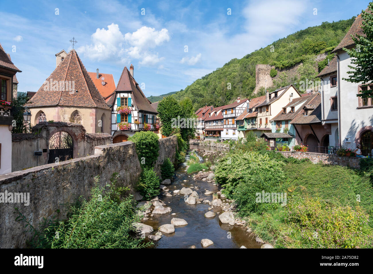 Metà di vecchie case con travi di legno e edifici nella città medievale di Kayserberg sul fiume Weiss, Alsace Francia Foto Stock