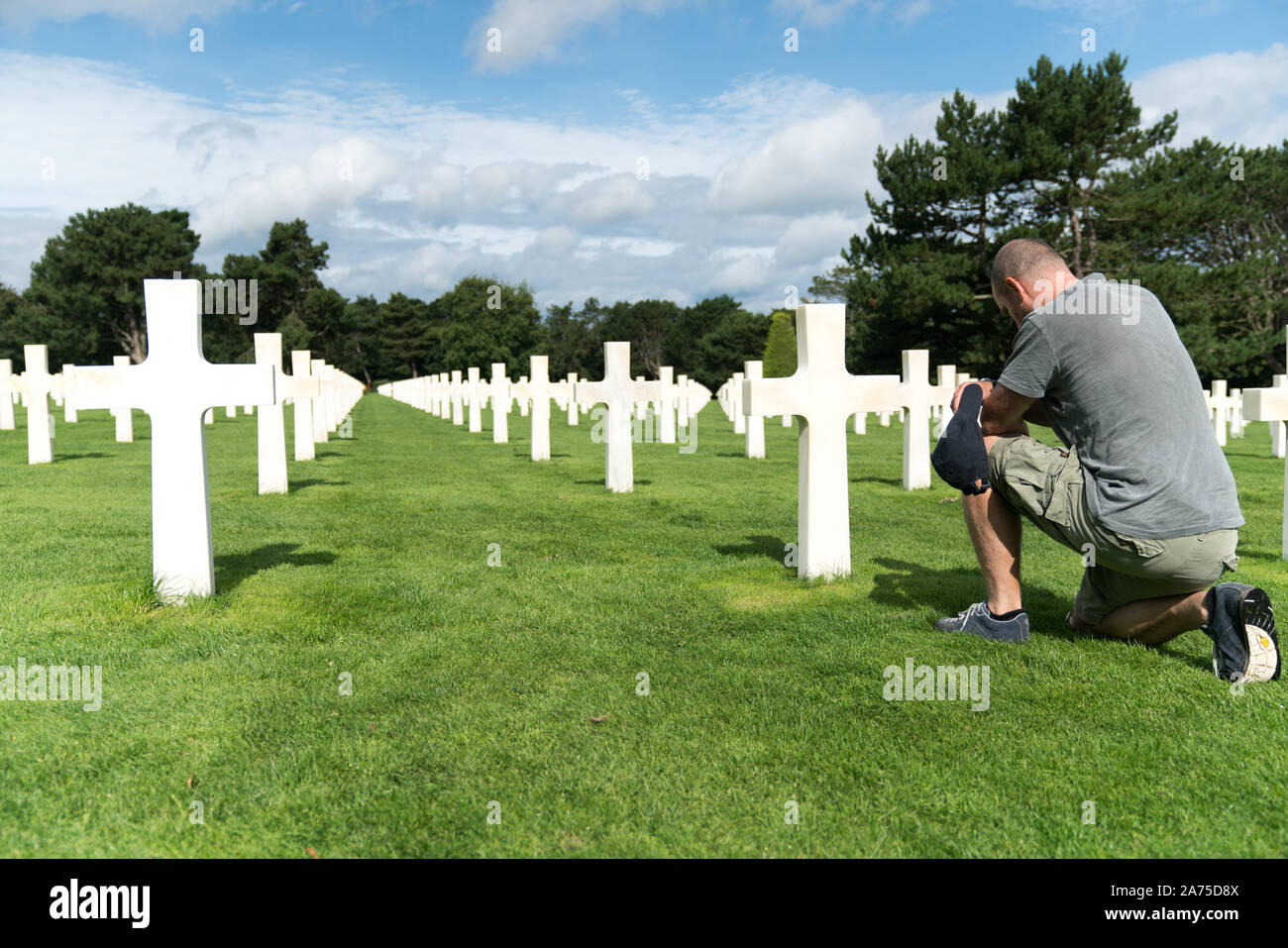 Colleville-sur-Mer, Calvados, Normandia / Francia - 16 agosto 2019: uomo di mezza età ricordando il suo nonno caduti presso il Cimitero Americano di Omah Foto Stock