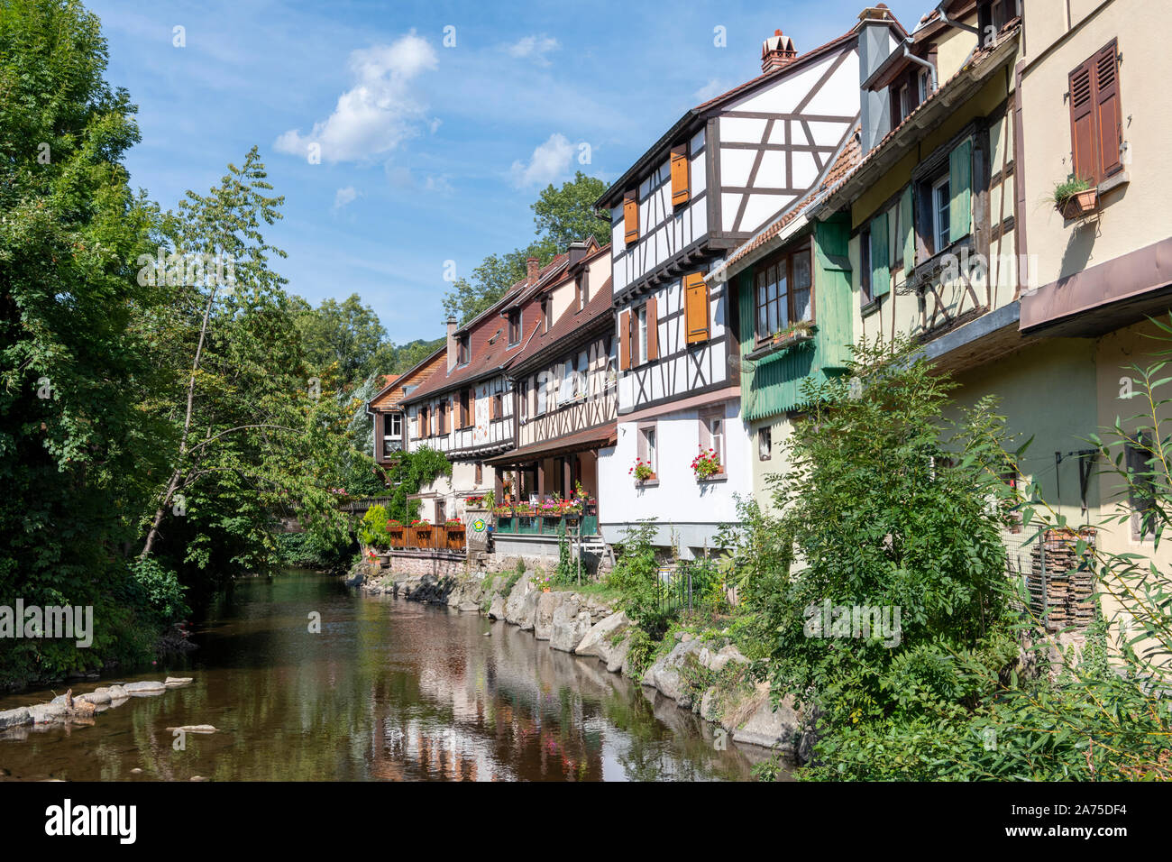 Metà di vecchie case con travi di legno e edifici nella città medievale di Kayserberg sul fiume Weiss, Alsace Francia Foto Stock