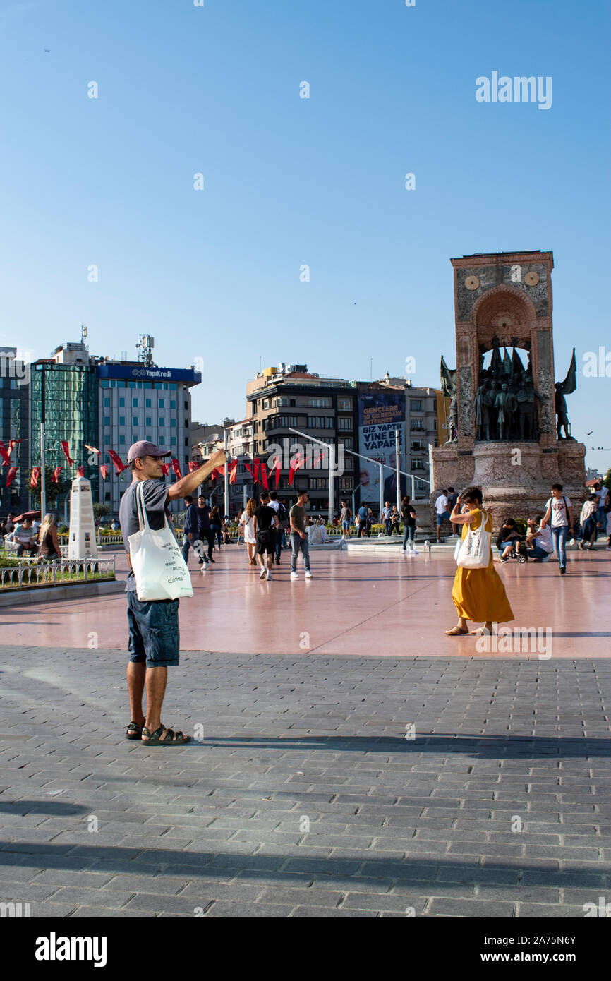 Istanbul, Turchia: persone in piazza Taksim con Repubblica monumento realizzato da Pietro Canonica per commemorare la formazione della repubblica turca nel 1923 Foto Stock
