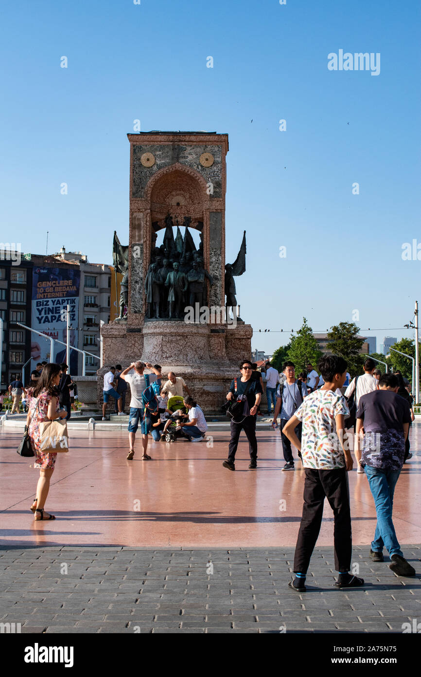 Istanbul: persone in piazza Taksim con la Repubblica monumento realizzato dagli italiani Pietro Canonica o commemorare la formazione della Repubblica turca nel 1923 Foto Stock