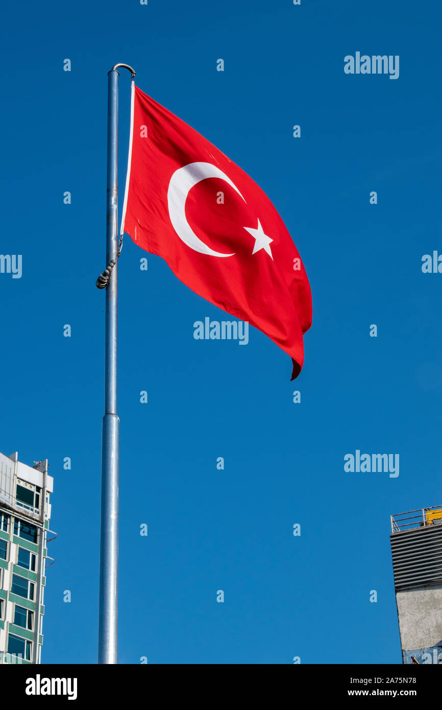 Istanbul, Turchia: bandiera turca sventolando nella famosa Piazza Taksim, cuore moderno di Istanbul in tutte le principali mete di svago e il quartiere di Beyoglu Foto Stock