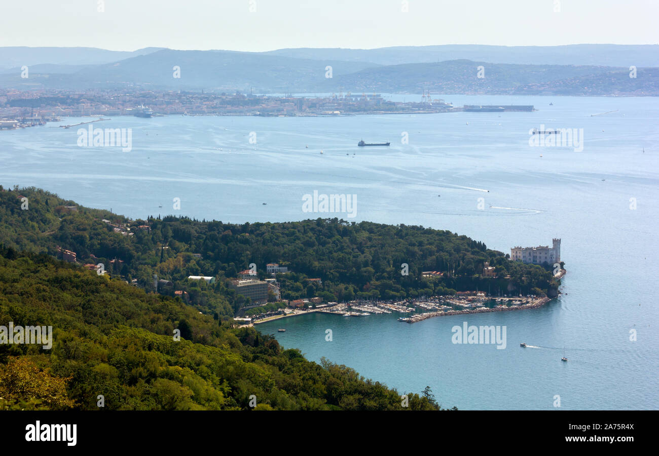 Marina di Grignano e il castello di Miramare e la città di Trieste, Italia, in background Foto Stock