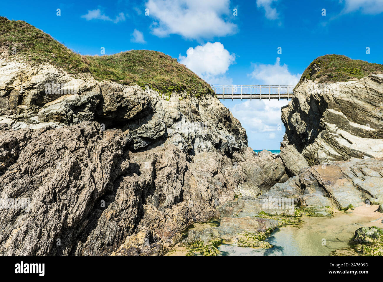 La passerella che collega la terraferma a Porth Island a Porth Beach in Newquay in Cornovaglia. Foto Stock