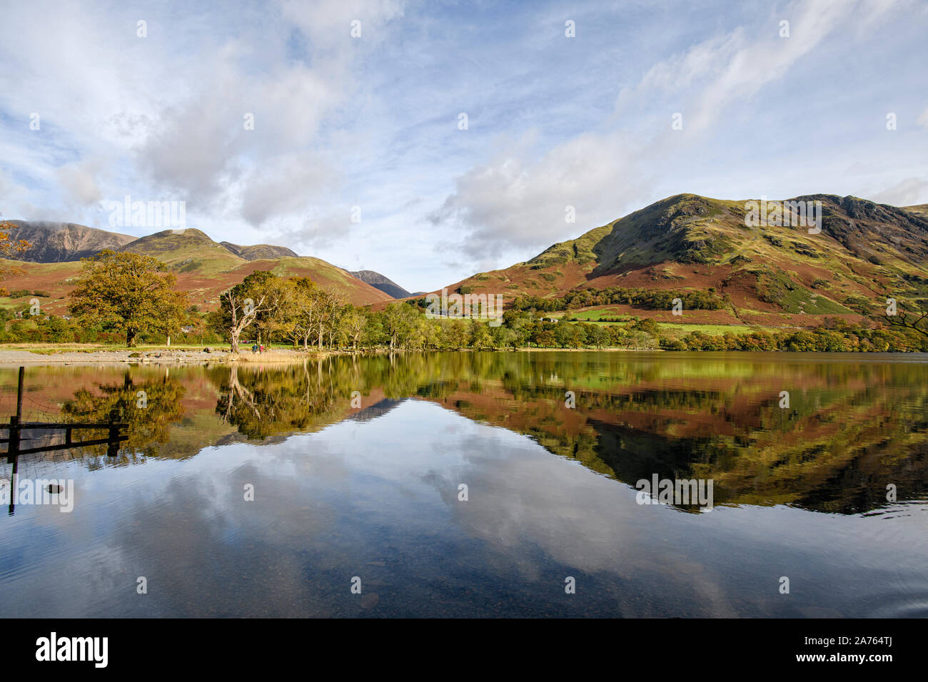 Autunno riflessioni degli alberi e fells intorno al litorale Buttermere Foto Stock
