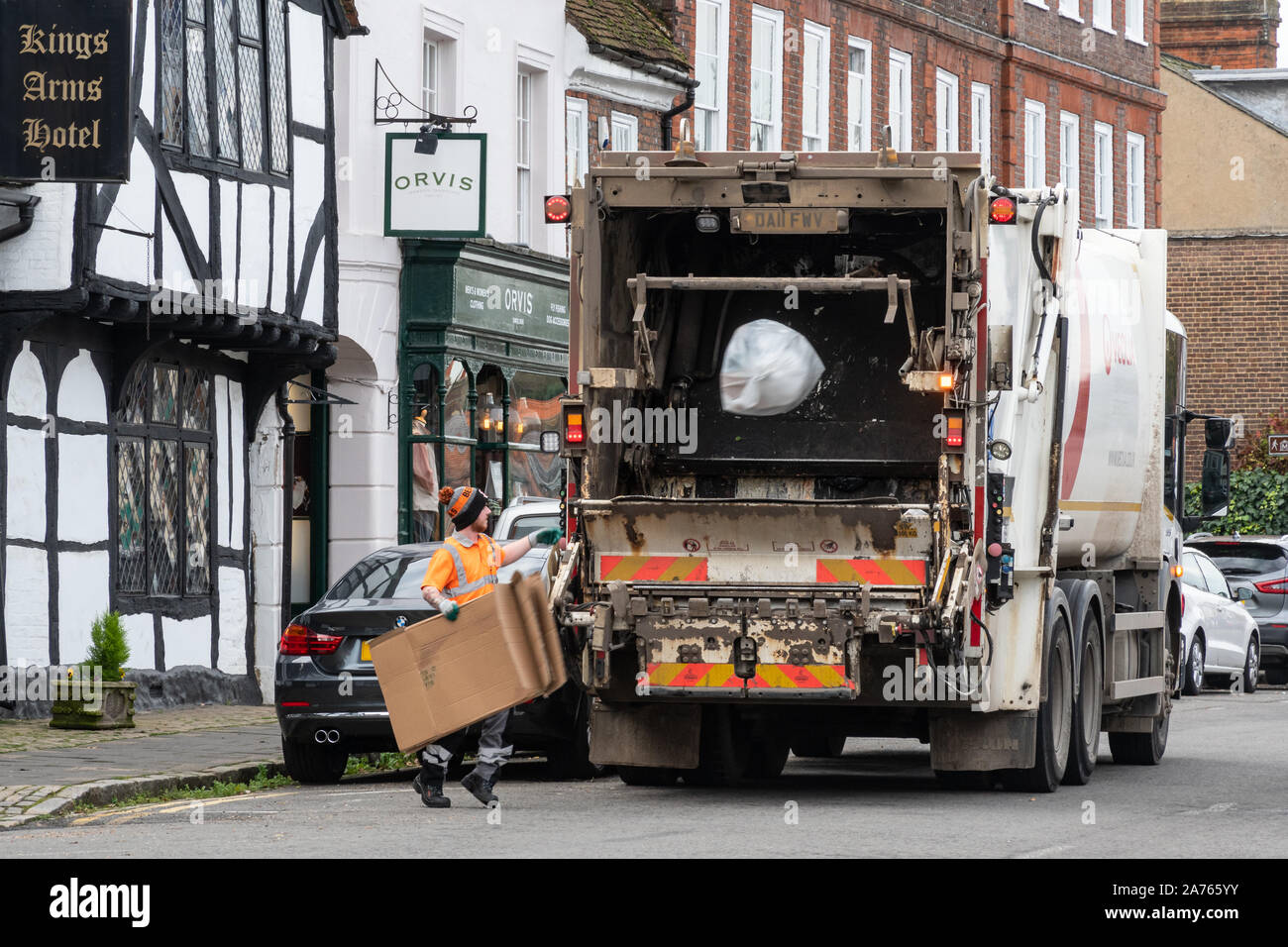 Workman gettando sacchetto di rifiuti in un cestino camion (camion della spazzatura) Foto Stock